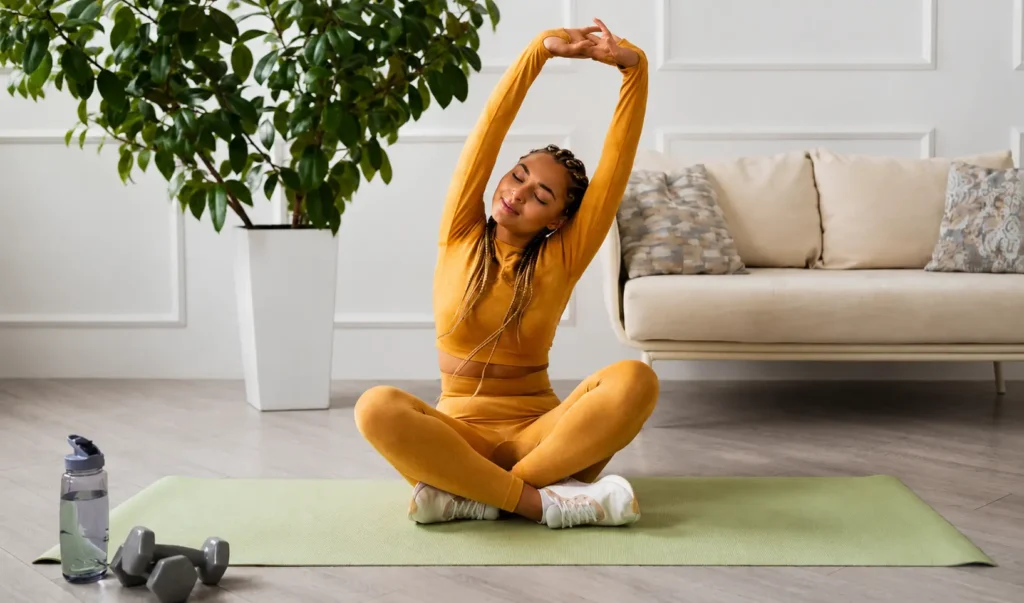 Woman stretching on a yoga mat at home to support healthy habits and daily movement