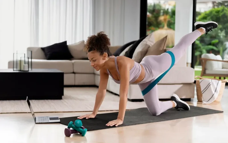 Woman doing a home workout with resistance band to build healthy habits and fitness consistency