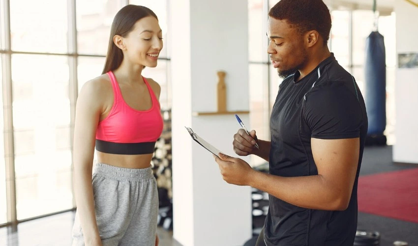 Personal trainer supporting beginner strength training