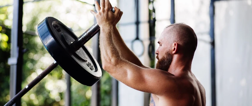 Person strength training in a gym while building muscle and improving fitness