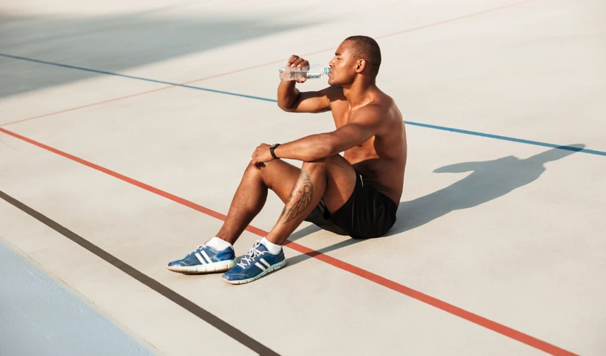 Athlete hydrating and recovering after a demanding workout