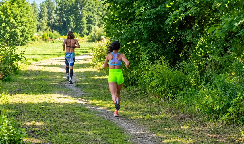 Two runners rebuilding fitness on an outdoor spring trail